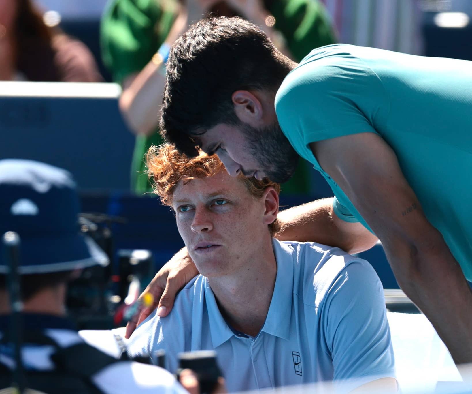 Carlos Alcaraz y Jannik Sinner en un momento de reflexión en la red tras un duelo de alta tensión.