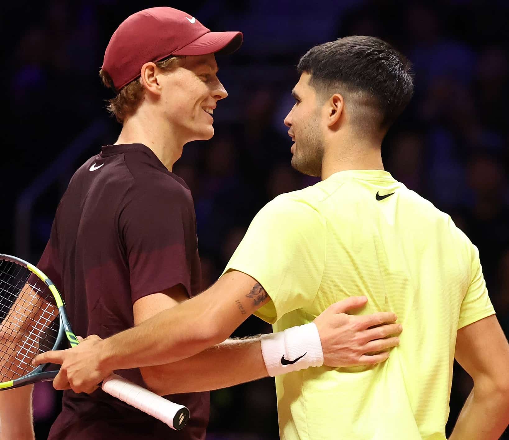 Carlos Alcaraz y Jannik Sinner saludándose en la red durante un partido de exhibición en 2026.