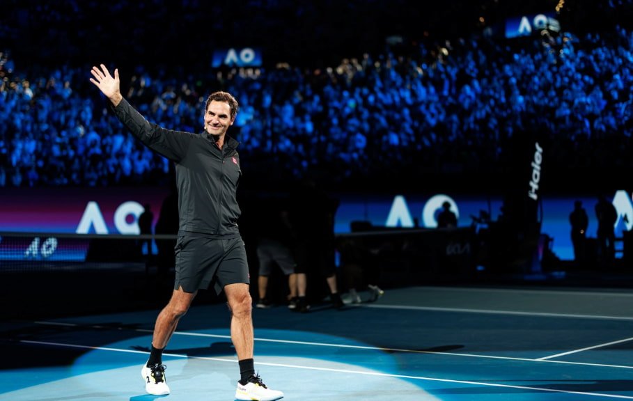 Roger Federer saludando a la multitud en un estadio de tenis, transmitiendo su legado eterno.