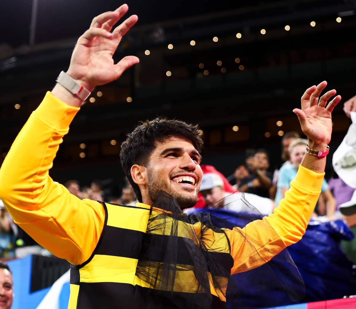 Carlos Alcaraz sonriendo mientras se pone un disfraz de abeja tras clasificar a semifinales de Indian Wells 2026.
