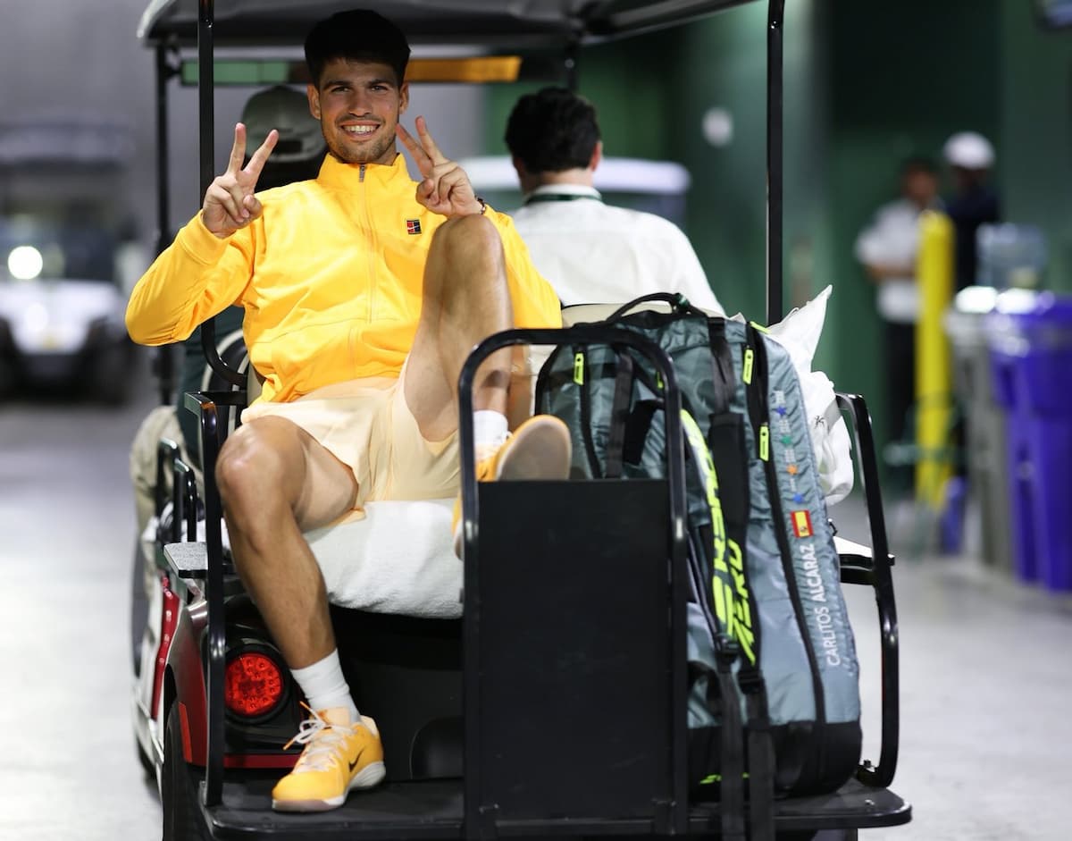 Carlos Alcaraz con los brazos en alto tras ganar un punto decisivo, rodeado del calor del público latinoamericano.