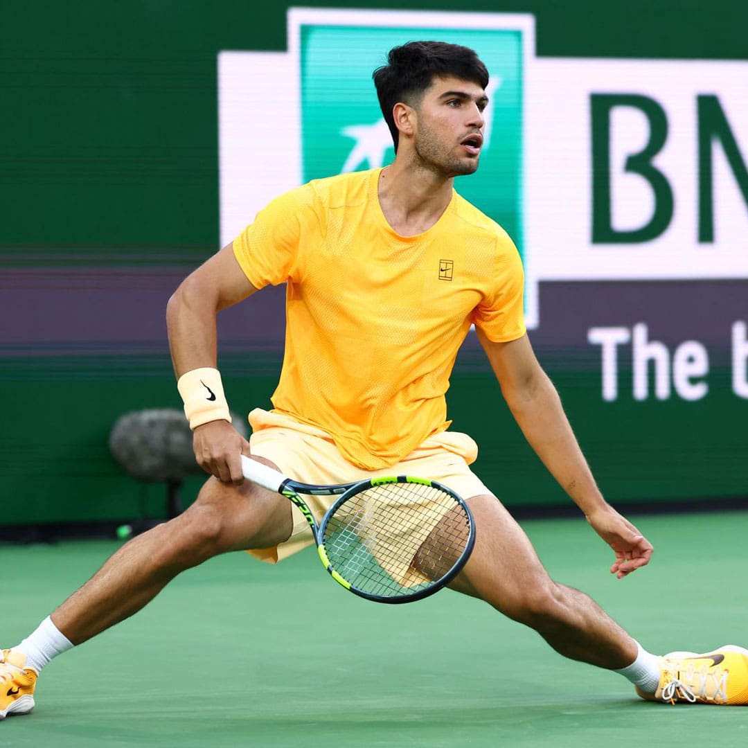 Carlos Alcaraz realiza un estiramiento extremo para conectar una derecha durante su debut en el BNP Paribas Open de Indian Wells 2026.