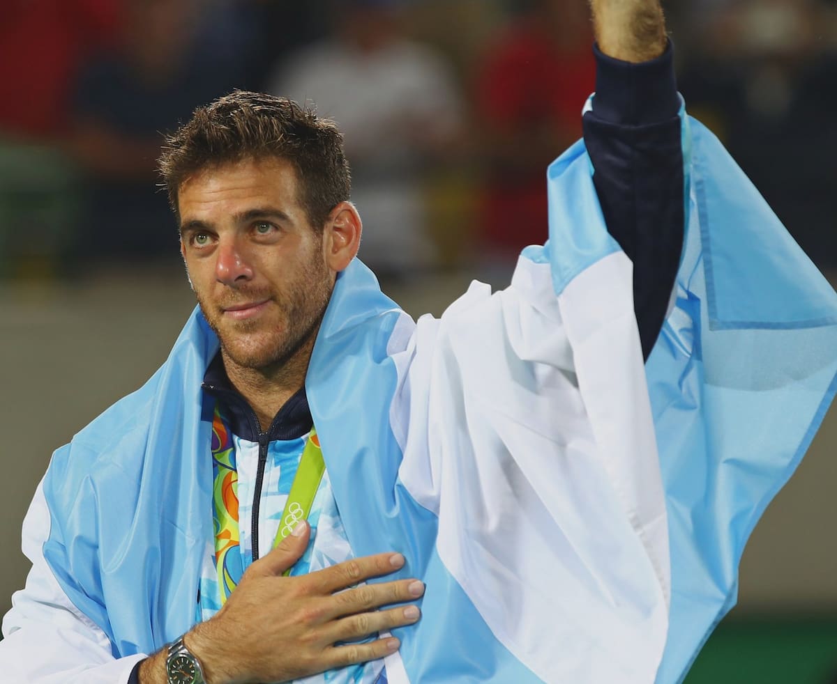 Juan Martín del Potro sonriendo con melancolía y cubierto con la bandera de Argentina tras ganar la medalla en los Juegos Olímpicos de Río 2016.