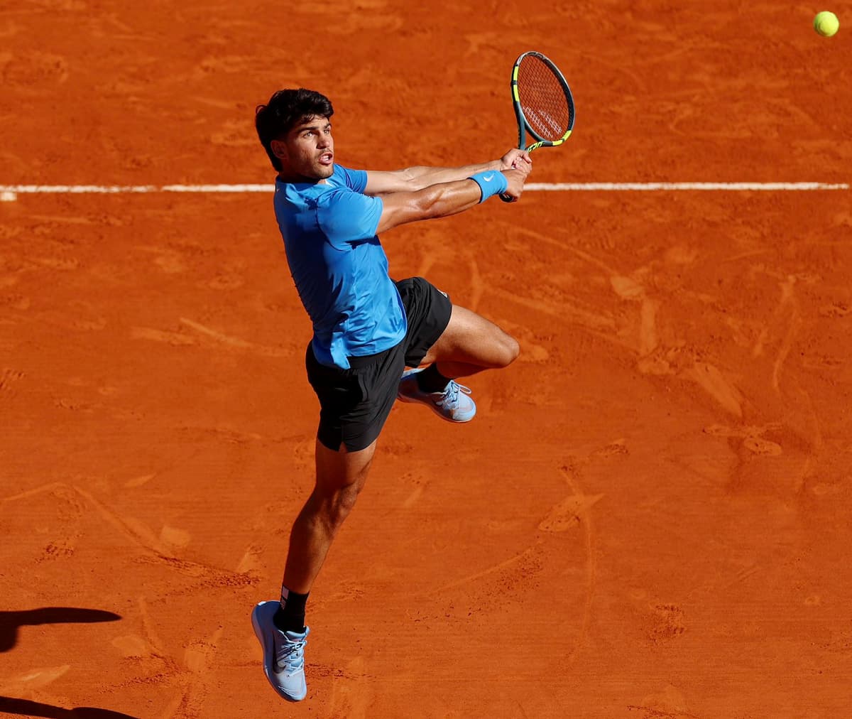Carlos Alcaraz en plena extensión de su golpe de derecha, mostrando la técnica perfecta que lo sitúa en la cima del poder ATP.