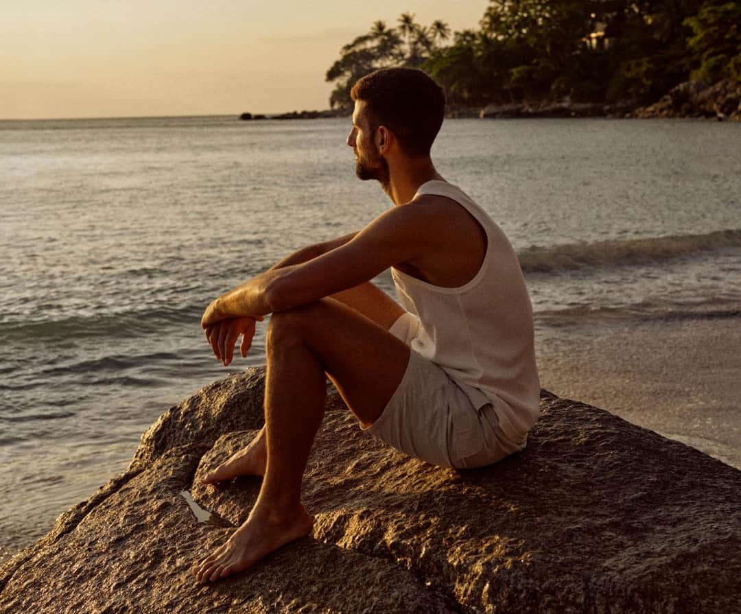 Novak Djokovic meditando en un entorno de lujo natural, representando su colaboración con Aman para los programas de longevidad y recuperación.