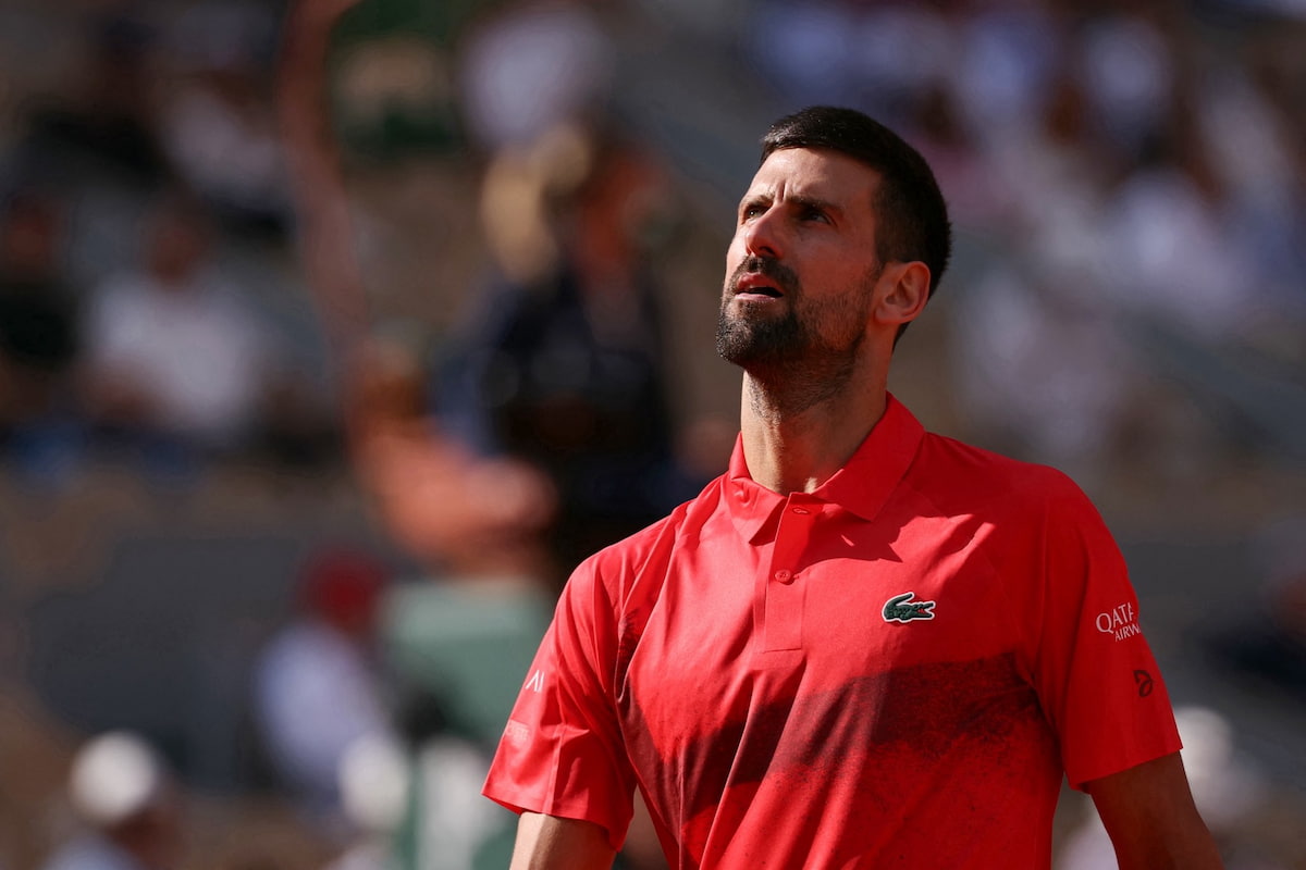 Novak Djokovic con gesto de preocupación y mirada al cielo durante una sesión de entrenamiento en tierra batida, reflejando sus dudas para competir en Madrid.