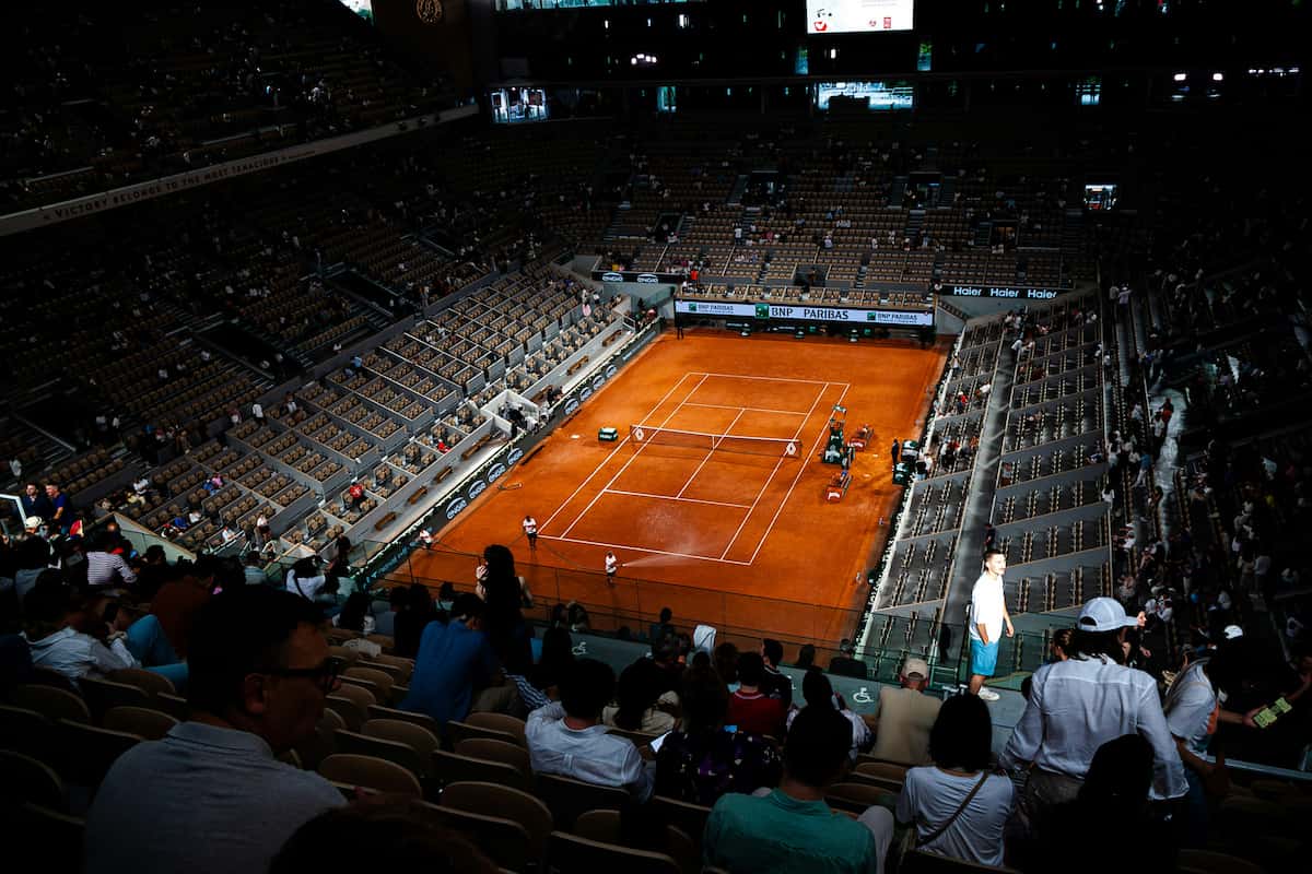 Detalle de un jugador de tenis portando un reloj inteligente de alto rendimiento durante un partido en Roland Garros.