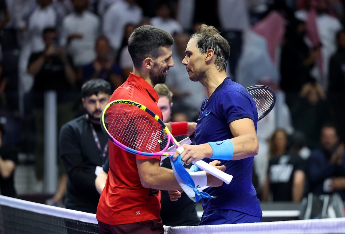 Novak Djokovic y Rafael Nadal saludándose en la red tras un partido, representando las raquetas subastadas por Prestige Memorabilia.